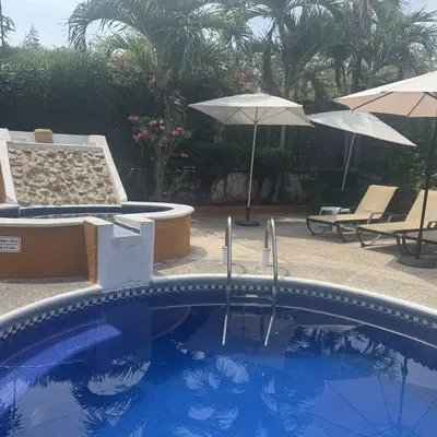Pool with sun loungers and umbrellas for guests