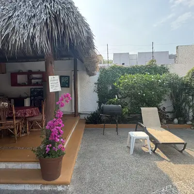 Palapa with a lounger and garden at Villas Mercedes